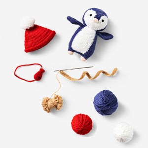 DIY crochet penguin hobby craft by Flying Tiger Copenhagen, showing a handmade black and white penguin with orange beak and flippers.