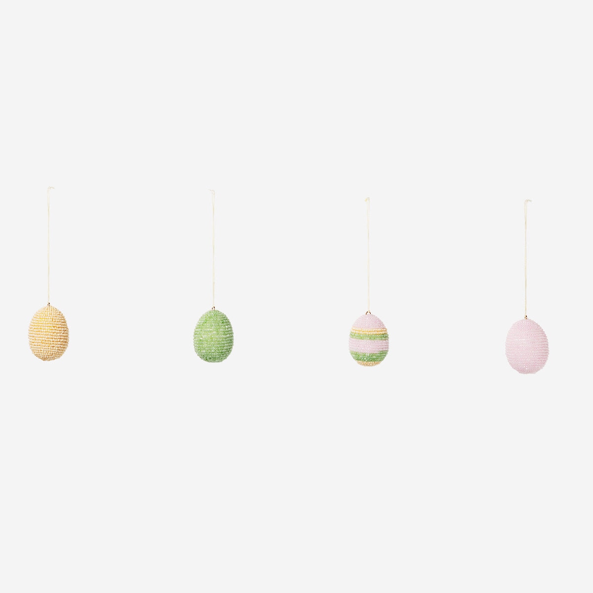 DIY Easter eggs with glass beads for crafting, featuring colorful glass bead decorations on a white background.