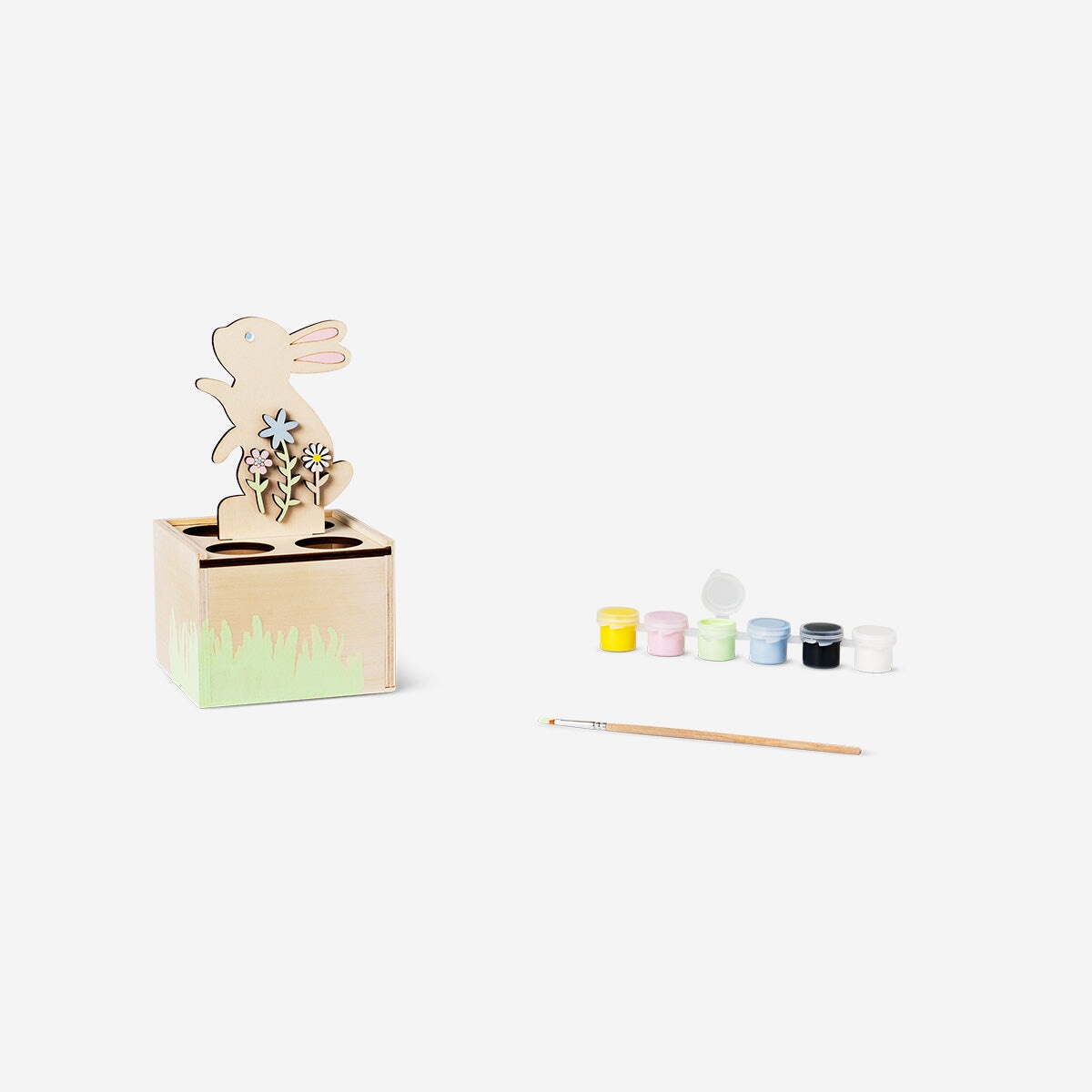 DIY egg stand with paint and brush for crafting, featuring a colorful cardboard base and art supplies for creative hobby projects.