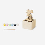 DIY egg stand hobby kit with paint and brush by Flying Tiger Copenhagen, featuring colorful painted eggs and crafting tools.