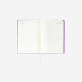 A5 purple daily diary 2026 by Flying Tiger Copenhagen, open to show date pages, office planner with colorful accents.