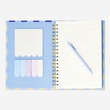 Flying Tiger Copenhagen office notebook with ballpoint pen and sticky memos on a desk for note-taking and organization.