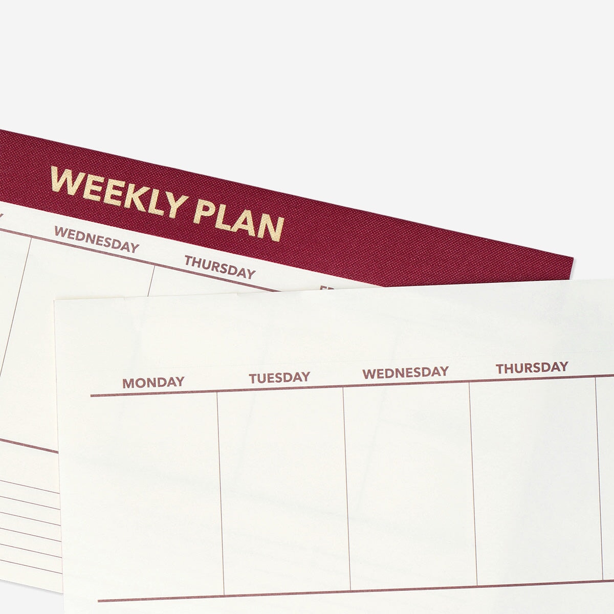 Red weekly desk planner from Flying Tiger Copenhagen, featuring organized pages for scheduling and note-taking.