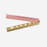 Rose foldable metal ruler for office use by Flying Tiger Copenhagen, showing a compact, pink metal ruler in a folded position.