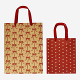 Two festive Christmas gift bags from Flying Tiger Copenhagen, designed for party gift wrapping, featuring holiday-themed patterns.