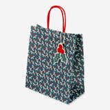 Party gift bag with debossed holly pattern from Flying Tiger Copenhagen, featuring festive holiday design and sturdy paper construction.