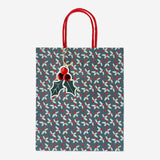 Party gift bag with debossed holly pattern from Flying Tiger Copenhagen, featuring festive holiday leaf designs.
