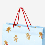 Party gift bag with gingerbread people design from Flying Tiger Copenhagen, featuring festive holiday-themed illustrations.