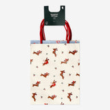 Four Christmas-patterned gift bags for parties from Flying Tiger Copenhagen, featuring festive holiday designs.