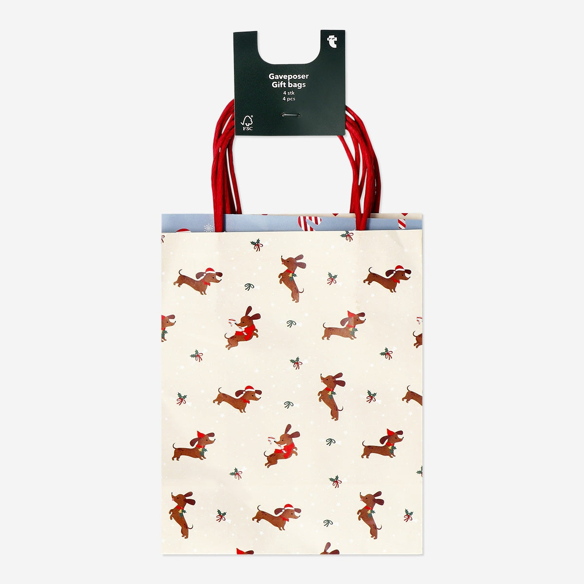 Four Christmas-patterned gift bags for parties from Flying Tiger Copenhagen, featuring festive holiday designs.