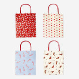 Set of four Flying Tiger Copenhagen Christmas-patterned gift bags for parties, featuring festive holiday designs.