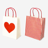 Two Flying Tiger Copenhagen gift bags with heart designs for parties, featuring colorful heart patterns on paper bags.