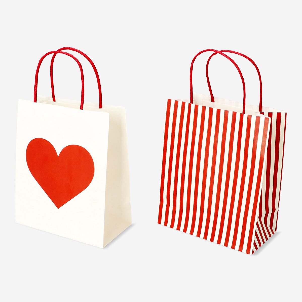 Two Flying Tiger Copenhagen gift bags with heart designs for parties, featuring colorful heart patterns on paper bags.