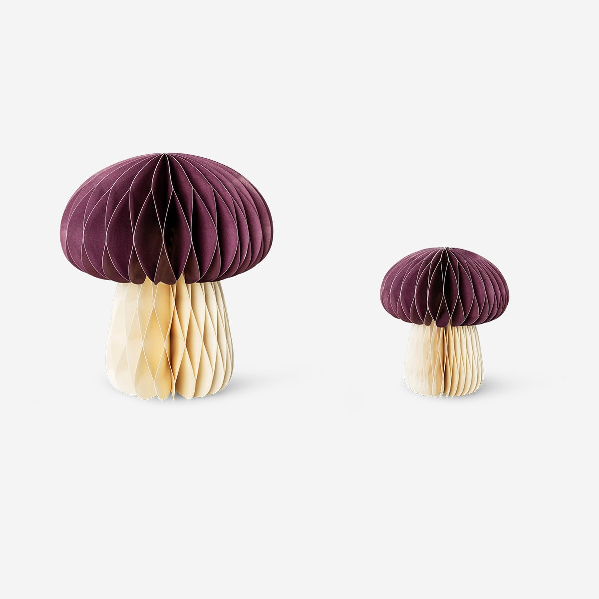 Two honeycomb mushroom table decorations for parties by Flying Tiger Copenhagen, featuring colorful, lightweight paper designs.