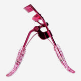 Pink glitter eyelash curler from Flying Tiger Copenhagen, a personal care tool for curling eyelashes with a shiny glitter finish.