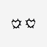 Black textile earrings with heart designs by Flying Tiger Copenhagen, featuring soft fabric and playful heart shapes.