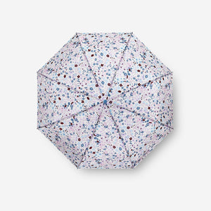 Small textile folding umbrella by Flying Tiger Copenhagen, showing its compact design and colorful canopy in a closed position.